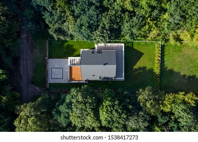 Aerial View Of Modern House With Green Lawn Surrounded By Forest