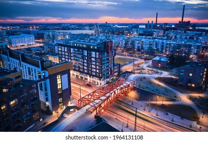 Aerial View Of The Modern Neighborhood Jatkasaari Of Helsinki, Finland. Modern Nordic Architecture. Orange Modern Bicycle-pedestrian Bridge Over The Street.