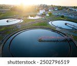 Aerial view of modern wastewater treatment plant with storage tanks in sunset. Ideal for wastewater management theme.