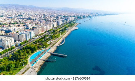 Aerial view of Molos Promenade park on coast of Limassol city centre,Cyprus. Bird's eye view of the jetty, beachfront walk path, palm trees, Mediterranean sea, piers, urban skyline and port from above - Powered by Shutterstock