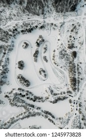 Aerial View To Motorcycle Rider On Snowy Motocross Track. Mx Rider On Snow. Motocross Rider On Bike, Motocross Winter Season Race. Drone View Racer Motorcycle Rides On Motocross Snowy Track In Winter.