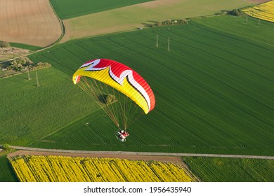 Vue aérienne d'un parapente motorisé survolant les champs de colza jaune au printemps. département d'Essonne, région Ile-de-France, France
