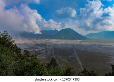 Aerial view of Mount Bromo with dramatic cloud formation and blue sky
