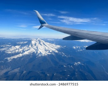 Aerial view of Mount Rainier with a plane wing in the foreground. Snow-capped peak and clear blue sky showcasing the stunning landscape of the Pacific Northwest. Ideal for travel and nature themes. - Powered by Shutterstock