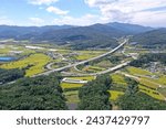 Aerial view of mountain and golden rice paddy with Dangjin Yeongdeok Expressway and Dongseongju IC at Gujam-ri near Sangju-si, South Korea
