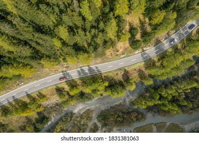 Aerial View Mountain Pass Road Traffic with creek and conifer tress. Concept: Go beyond, out and about, close to nature, back to the roots
