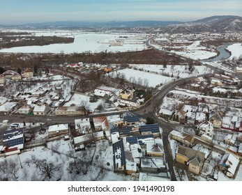 Aerial View Of Mukachevo Zakarpattia, Ukraine. Roofs Covered With Snow, Winter View Of The City. Solar Panels On The Roof, Energy Independence, Green Tariff, Alternative Energy Sources