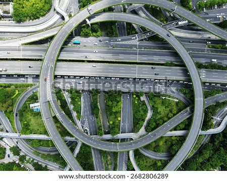 Aerial view of a multi - level interchange near Fuzhou Railway Station, with highways, vehicles, and greenery interwoven.