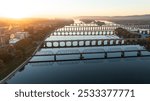 Aerial view of multiple bridges crossing the Susquehanna River at sunrise in Harrisburg, Pennsylvania, with the city skyline and surrounding landscapes bathed in golden light.
