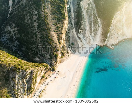 Aerial view of Myrtos beach, the most famous and beautiful beach of Kefalonia, a large coast with turqoise water and white coarse sand, surrounded by steep cliffs. Cephalonia, Greece.