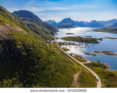 Aerial view of the nature in Lofoten, Norway on a clear summer day. Calm waters, deep blue colours. Spectacular road E10 towards Reine.