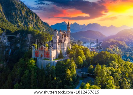 Aerial view of Neuschwanstein Castle with scenic mountain landscape near Fussen, Bavaria, Germany. Neuschwanstein castle at sunset, Germany. Neuschwanstein castle one of the most popular palace.