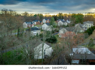 Aerial View Of New American Upper Middle Class Residential Neighborhood Streets With Luxury Single Family Homes With Sunset Sky