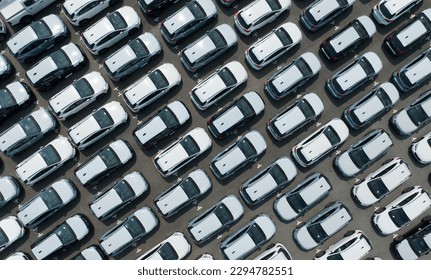 Aerial view of new cars stock at factory parking lot. Above view cars parked in a row. Automotive industry. Logistics business. Import or export new cars at warehouse. Big parking lot at port terminal - Shutterstock ID 2294782551