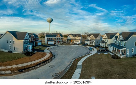 Aerial View Of New Construction Street With Luxury Houses In Cul-de-sac Upper Middle Class Neighborhood American Real Estate Development In The USA With Dreamy Blue Cloudy Sky And Water Tower	
