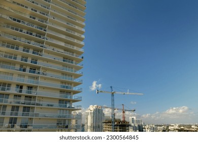 Aerial view of new developing residense in american urban area. Tower cranes at industrial construction site in Miami, Florida. Concept of housing growth in the USA
