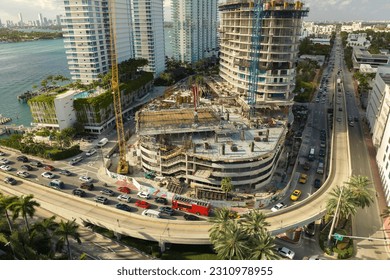 Aerial view of new developing residense in american urban area. Tower cranes at industrial construction site in Miami, Florida. Concept of housing growth in the USA - Shutterstock ID 2310978955