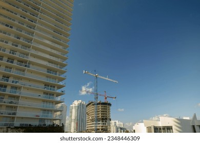 Aerial view of new developing residense in american urban area. Tower cranes at industrial construction site in Miami, Florida. Concept of housing growth in the USA
