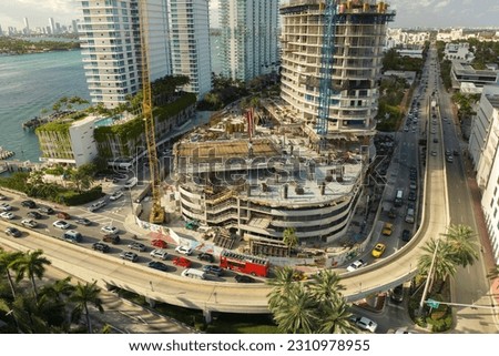 Aerial view of new developing residense in american urban area. Tower cranes at industrial construction site in Miami, Florida. Concept of housing growth in the USA