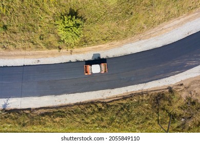 Aerial View Of New Road Construction With Steam Roller Machine At Work.