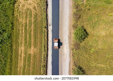 Aerial View Of New Road Construction With Steam Roller Machine At Work.