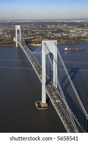 Aerial view of New York City's Verrazano-Narrow's bridge with tanker ship in water.