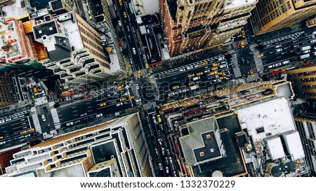 Aerial view of New York downtown building roofs. Bird's eye view from helicopter of cityscape metropolis infrastructure, traffic cars, yellow cabs moving on city streets and crossing district avenues