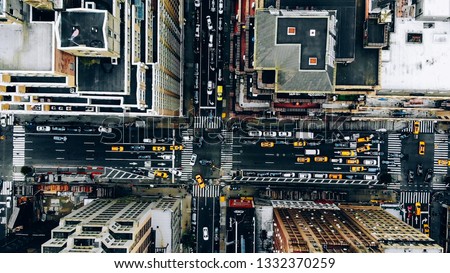 Aerial view of New York downtown building roofs. Bird's eye view from helicopter of cityscape metropolis infrastructure, traffic cars, yellow cabs moving on city streets and crossing district avenues