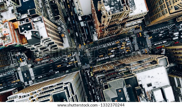 Aerial view of New York downtown building roofs.\
Bird\'s eye view from helicopter of cityscape metropolis\
infrastructure, traffic cars, yellow cabs moving on city streets\
and crossing district\
avenues
