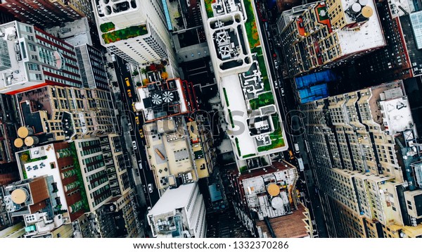 Aerial view of New York downtown building roofs
with water towers. Bird's eye view from helicopter of cityscape
metropolis infrastructure, traffic cars moving on city streets and
district avenues