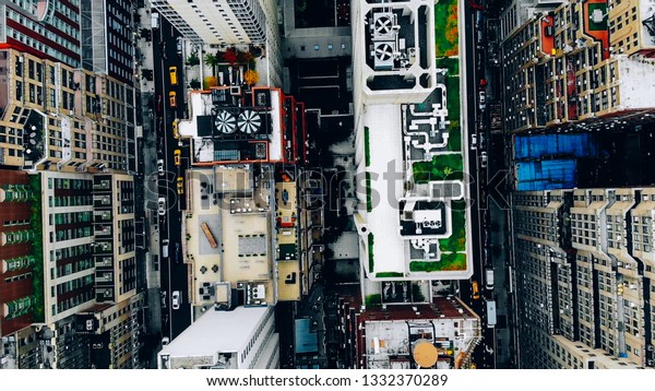 Aerial view of New York downtown building roofs\
with water towers. Bird\'s eye view from helicopter of cityscape\
metropolis infrastructure, traffic cars moving on city streets and\
district avenues