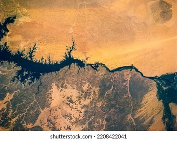 Aerial view of Nile River, Lake Nasser, Aswan Dam, Egypt. The difference between two region that reach water and those that do not. Drought concept background. Elements of this image furnished by NASA - Powered by Shutterstock