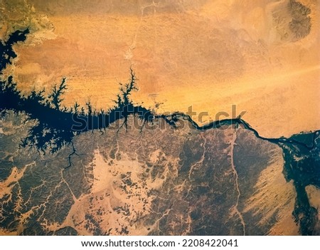 Aerial view of Nile River, Lake Nasser, Aswan Dam, Egypt. The difference between two region that reach water and those that do not. Drought concept background. Elements of this image furnished by NASA