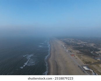 Aerial view of Nimbus Beach with gentle waves lapping the shore and a misty horizon - Powered by Shutterstock