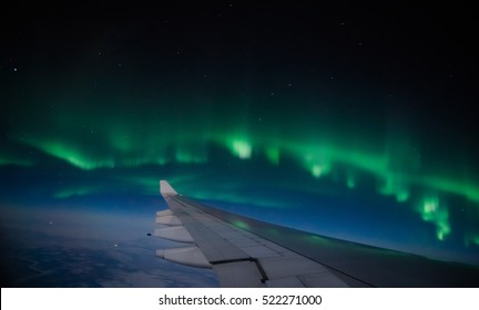 Aerial view of Northern Lights (Aurora Borealis) from an airplane flying over Northern hemisphere