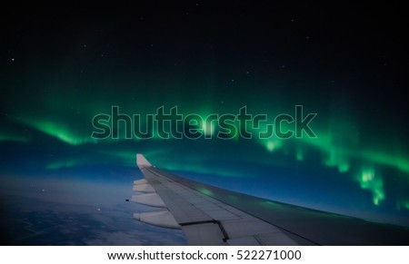 Aerial view of Northern Lights (Aurora Borealis) from an airplane flying over Northern hemisphere