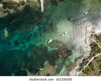 Aerial View Of Ocean Bay Near Shore With Yacht Ships Anchored In Front Of Coast. Shallow Sea Floor From Above.