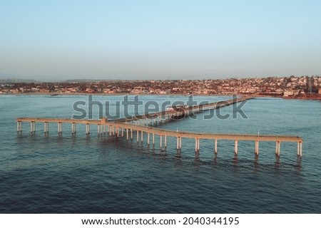 Aerial view of Ocean Beach Pier in San Diego, looking back with view of coast and town. 
