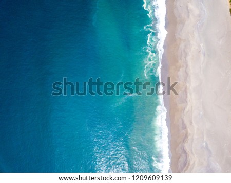 Aerial view of the ocean waves washing on the coast of the Pacific ocean