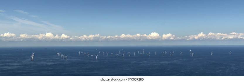 Aerial view of off shore windpark Luchterduinen. The windmills are in the Noordzee, 20 kilometers from the Dutch coastline between Noordwijk and Zandvoort. On the clear horizon a beautiful cloudstreet