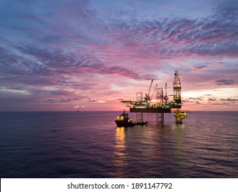 Aerial view offshore drilling rig (jack up rig) at the offshore location during sunset