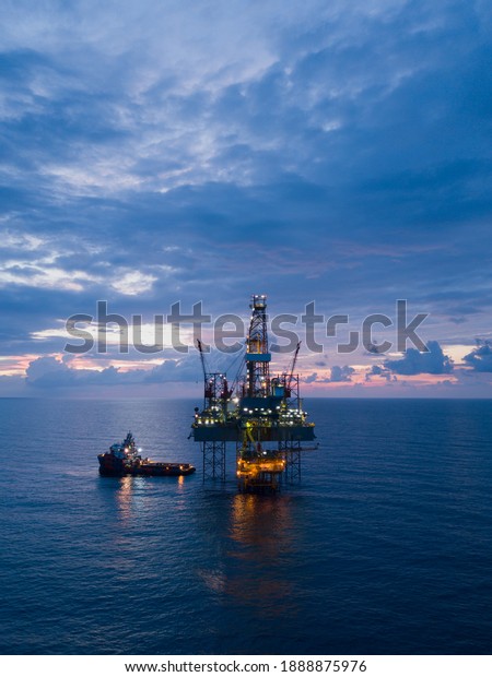 Aerial view offshore drilling rig (jack up\
rig) at the offshore location during\
sunset