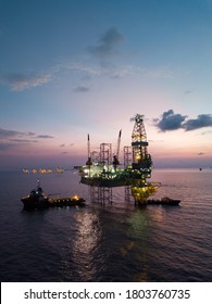 Aerial view offshore jack up rig at the offshore location during sunset with supply vessels and CPP