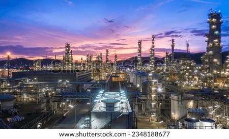Aerial view oil and gas tank with oil refinery background at night, Glitter lighting of petrochemical plant with night, Manufacturing of petroleum, Products tank in petrochemical plant.