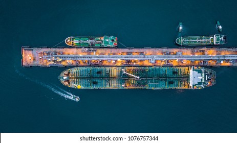 Aerial view of oil tanker ship at the port, Oil terminal is industrial facility for storage of oil and petrochemical products ready for transport to further storage facilities.