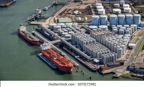 Aerial view of oil tankers moored at an oil storage silo terminal port.