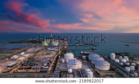 Aerial view oil terminal and coal power plant station in sea, White oil storage tank chemical petroleum petrochemical refinery product, Tanker ship at deep ocean seaport terminal.