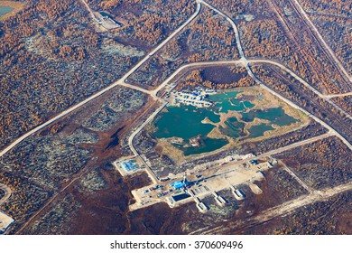 Aerial View Of The Oilfield In Tundra In Autumn. Some Gas Pipelines Running From Gas Field In Tundra. Oil Pumps Are Located In The Foreground.