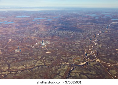 Aerial View Of The Oilfield In Tundra In Autumn. Some Gas Pipelines Running From Gas Field In Tundra. Oil Processing Plant Is Located In The Foreground.