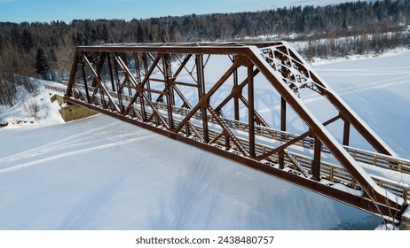 Aerial view of an old railway bridge spanning an icy river and now serving as a winter trail - Powered by Shutterstock